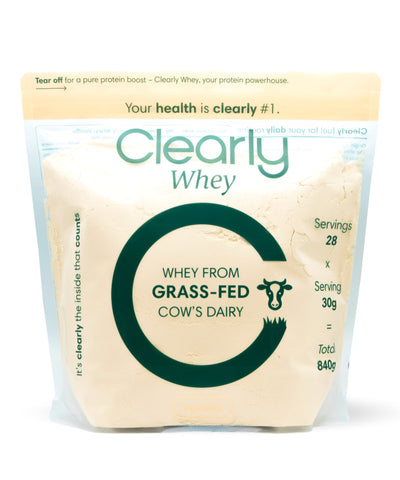Clearly Grass-fed Whey Powder in a scoop, showing the protein powder's natural texture and packaging front.