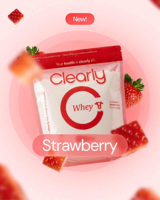 Clearly Grass-fed Whey powder with strawberry flavor, featuring a scoop and vibrant pink strawberry imagery on the front.
