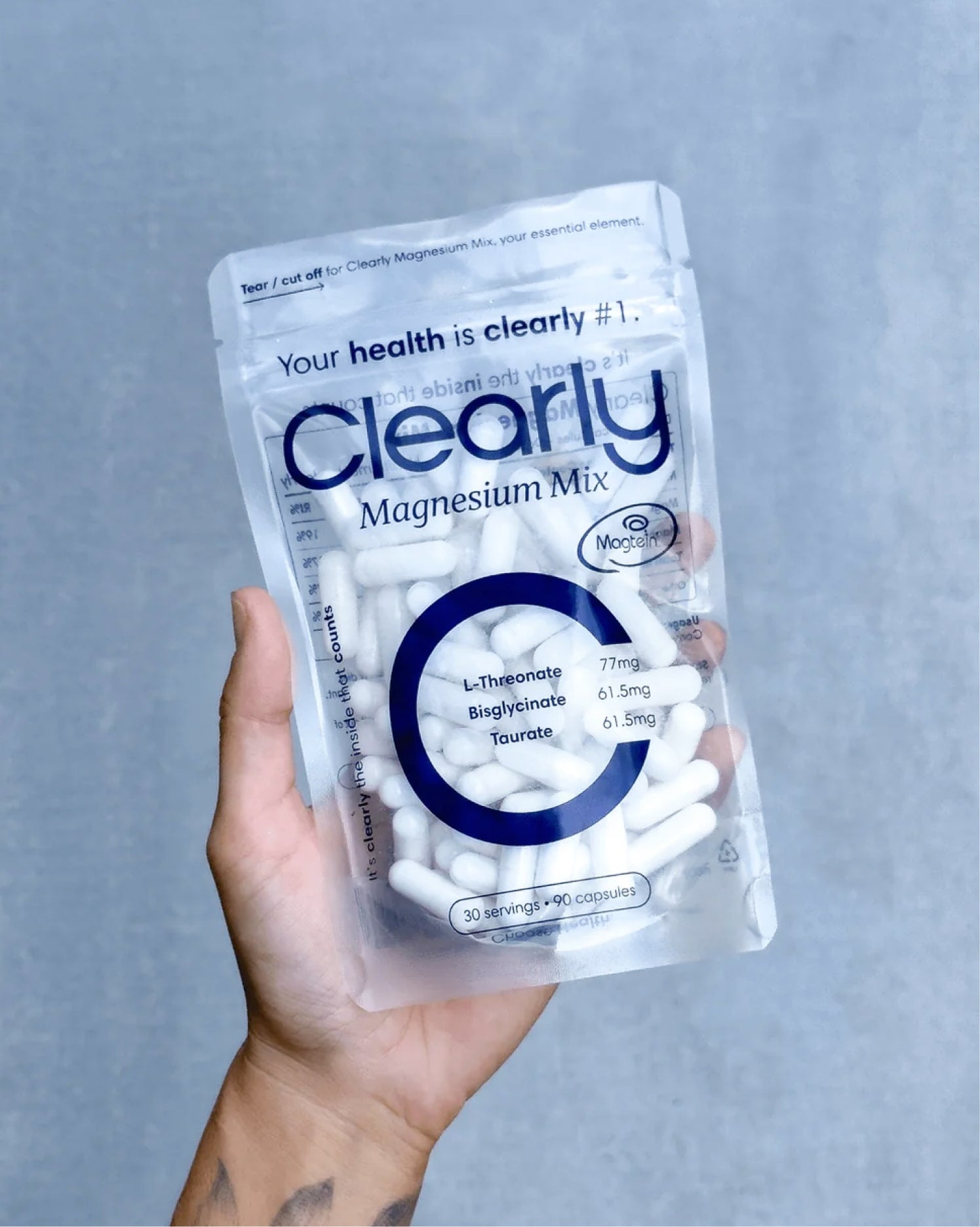 Clearly Magnesium Mix supplement in a clear container with a scoop, showing the magnesium powder inside.